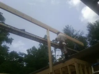Carpenter setting a ridge beam over a new addition frame — Ice Dam Removal by Roofing Brothers in Wynnewood