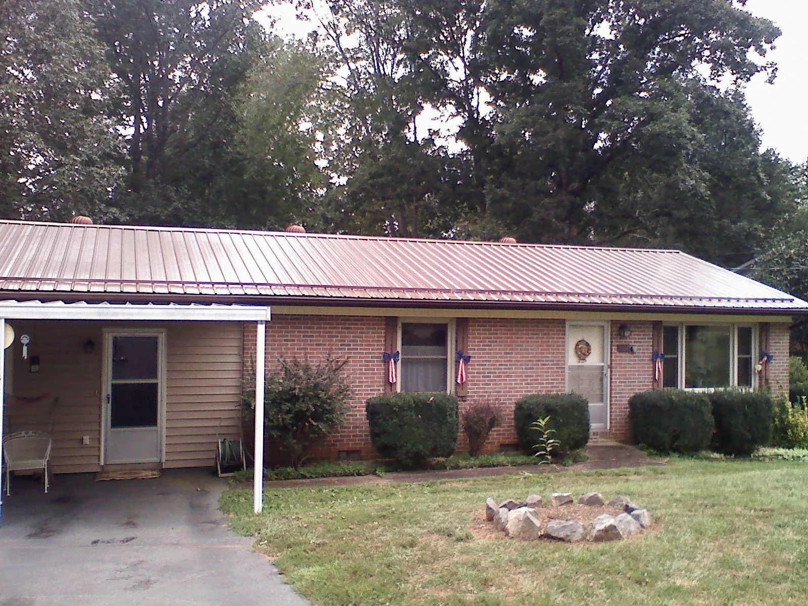 Bronze metal roof and carport on a brick ranch home — Roof Repair work by our crew in Wynnewood
